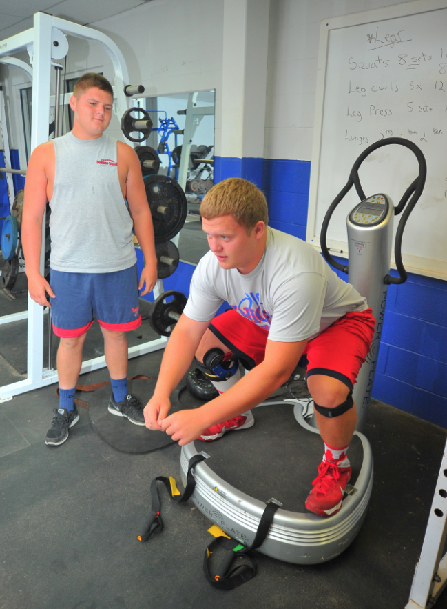 Wyatt Snow (left) waits his turn on a vibration training machine while Bryce Burgett gets a workout in earlier this summer.  Dan Starcher photo/courtesy The Daily Record