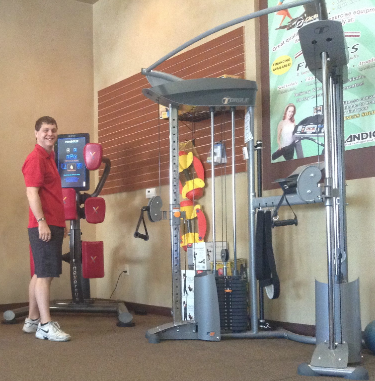 At Home Fitness-Gilbert store manager Tony Baird shows off a Nexersys Interactive Striking Trainer, while an Inspire FT2 Functional Trainer is pictured on the right.