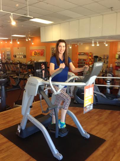 At Home Fitness store manager Jaime Janman stands on the brand new Octane Zero Runner. The Michigan native said she enjoys working for AHF because the company "really cares about its employees and customers."